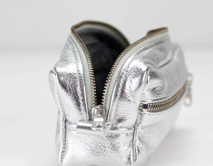 Silver metallic pouch with a zipper on a white background