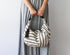 Person holding a striped handbag against a plain background