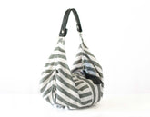 Gray and white striped bag with a black handle on a white background