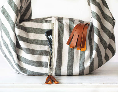 Striped bag with leather tassels on a white background