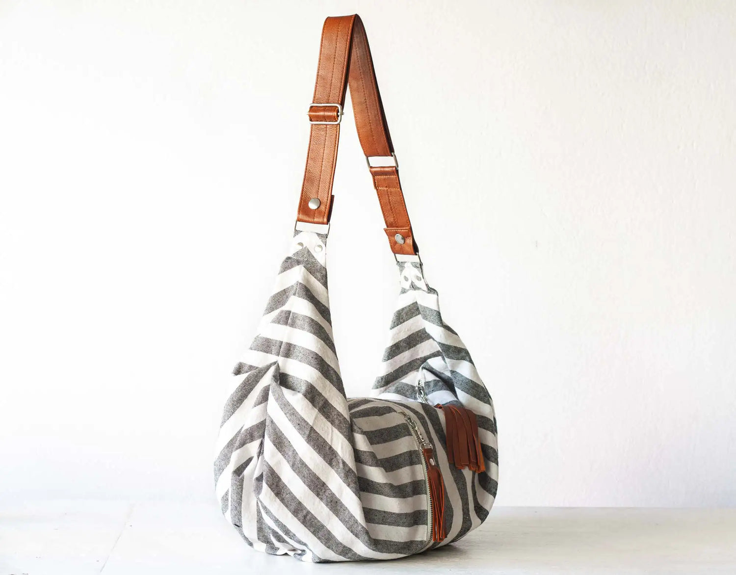 Striped handbag with brown leather straps on a white background