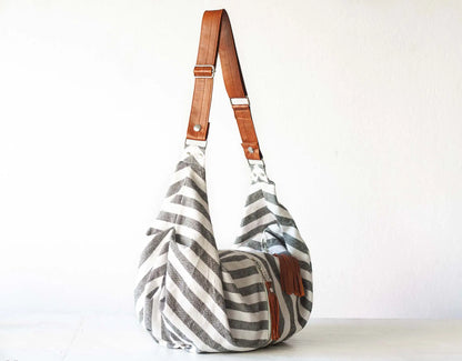Striped handbag with brown leather straps on a white background