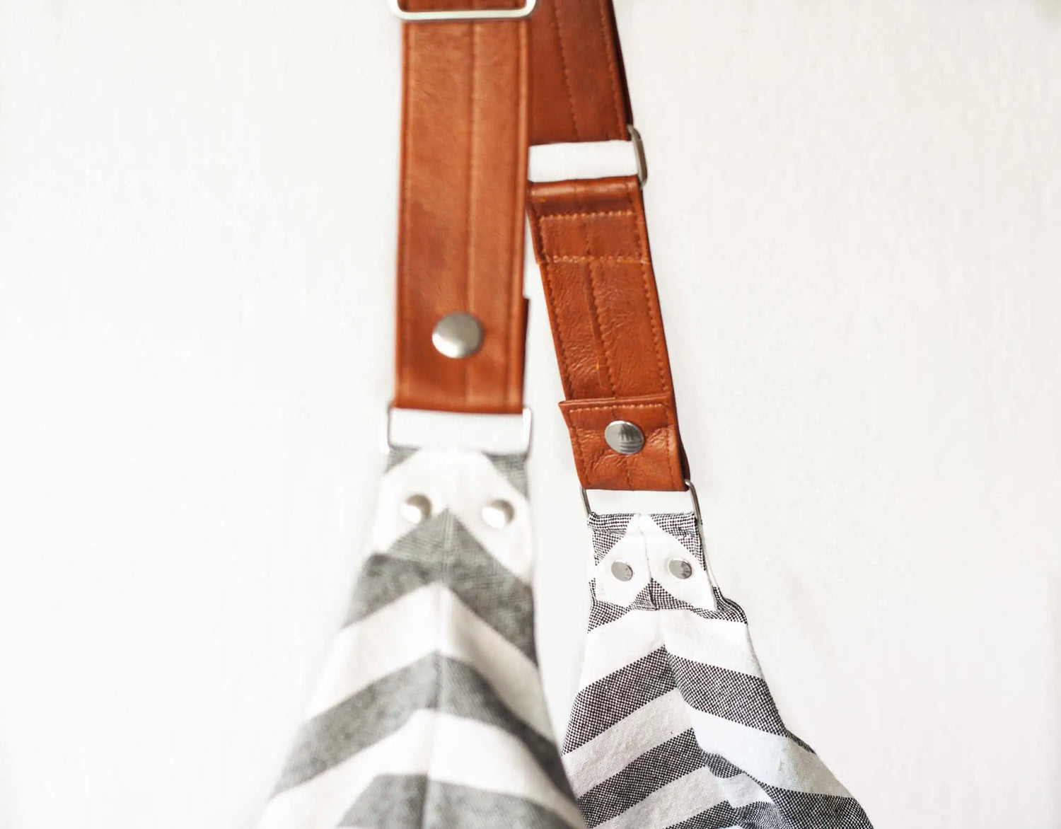 Gray and white chevron patterned strap with brown leather accents on a white background