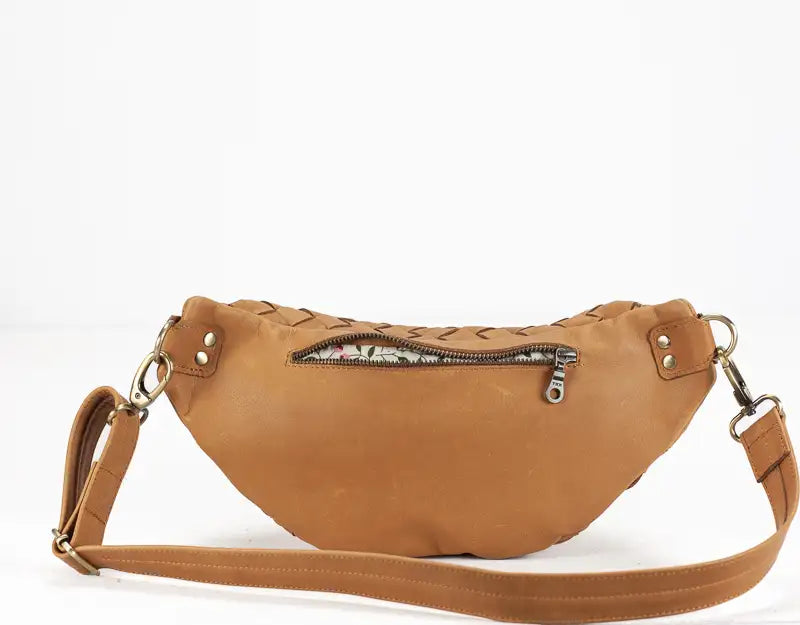 Brown leather waist bag with a strap on a white background