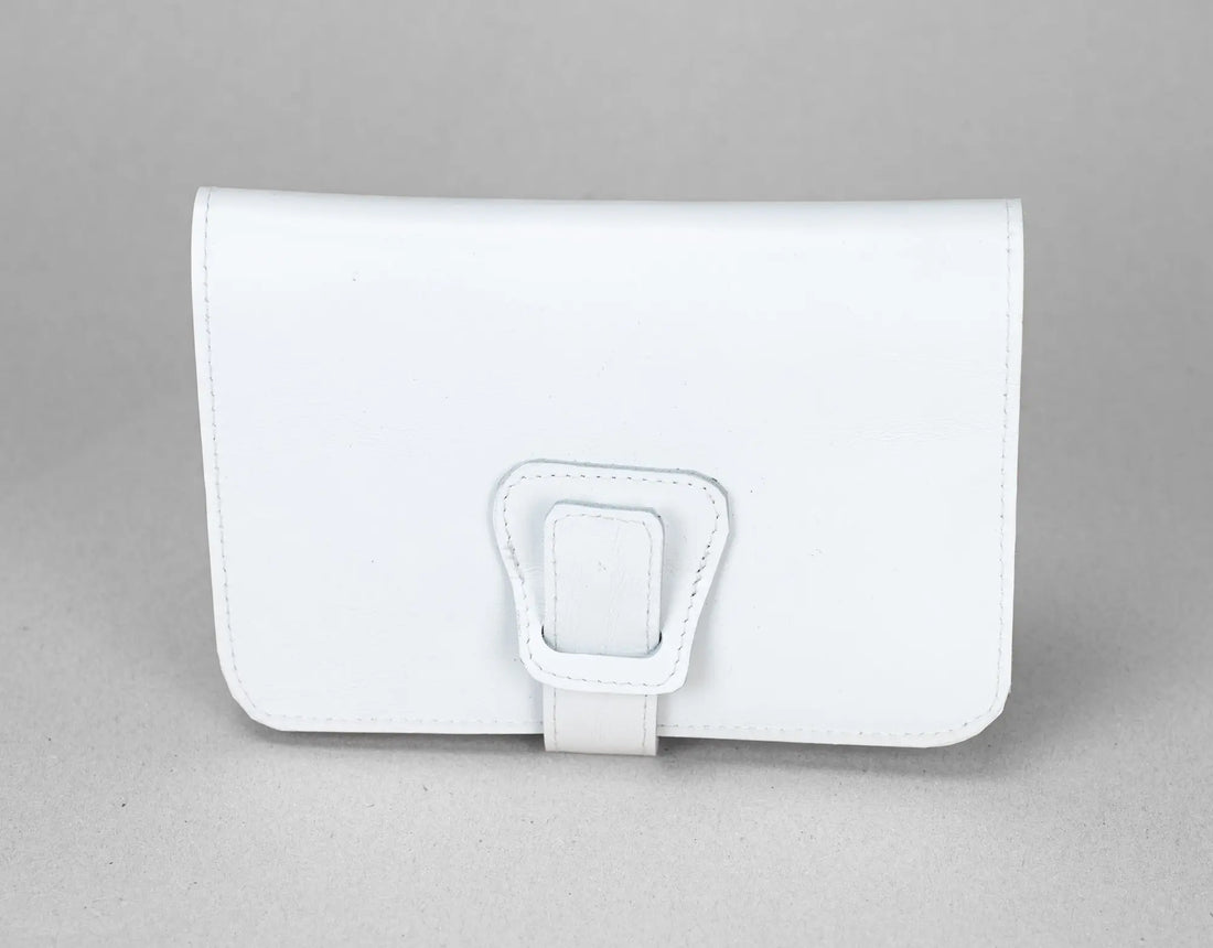 White leather wallet with a buckle on a gray background