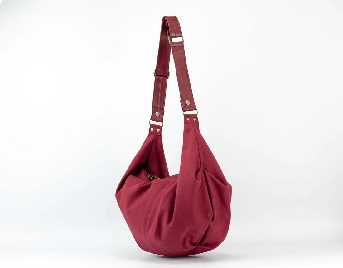 Red handbag with a strap on a white background