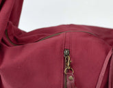 Close-up of a maroon bag with a zipper on a white background