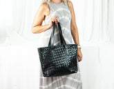 Person holding a black woven handbag 