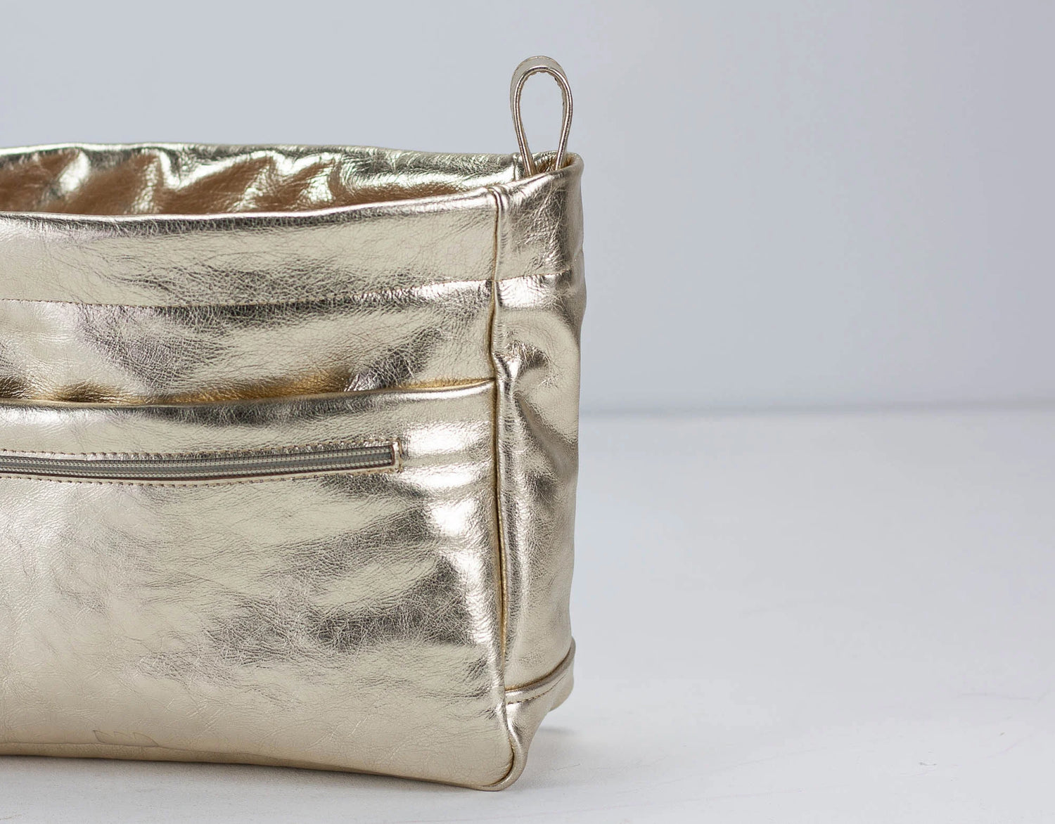 Metallic yellow gold bag on a light gray background