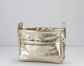 Metallic yellow gold handbag on a light gray background