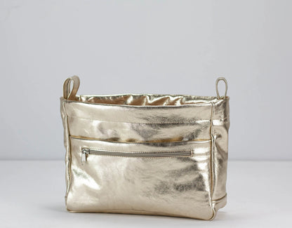 Metallic yellow gold handbag on a light gray background